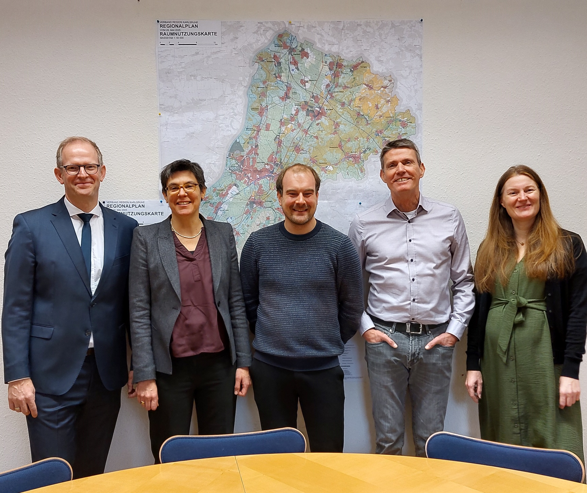Fünf Personen des Planungsteams vor der Raumnutzungskarte des neuen Regionalplans 2025