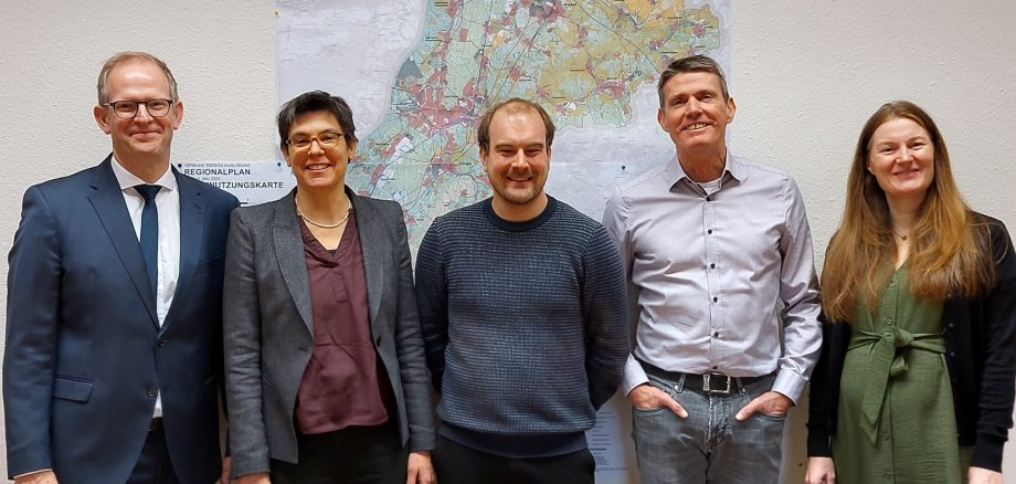 Fünf Personen des Planungsteams vor der Raumnutzungskarte des neuen Regionalplans 2025